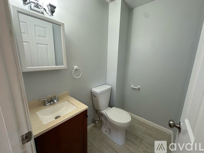 A white toilet sits next to a sink in a small bathroom.