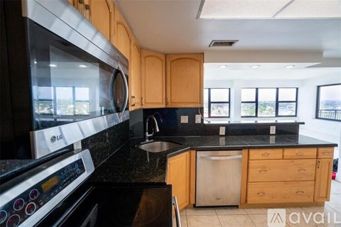 A kitchen with wooden cabinets and a black countertop.