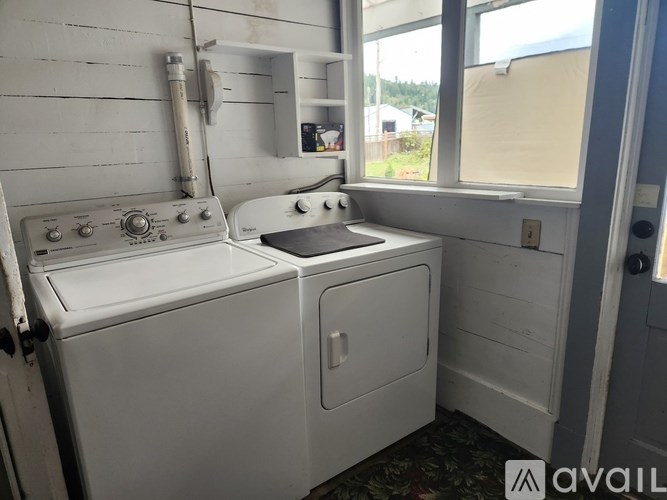 A white washing machine and dryer in a small laundry room.