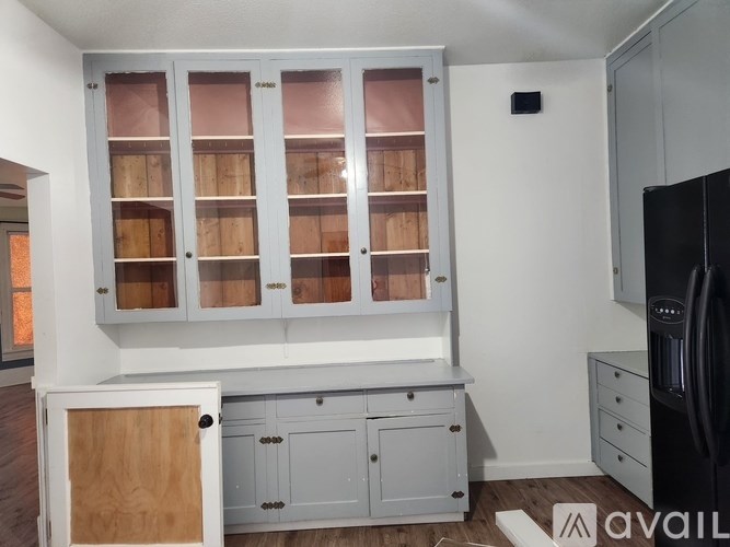 A kitchen with a white cabinet and a black fridge.