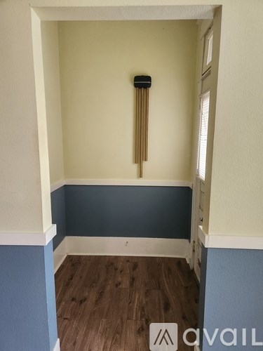 A room with a blue wall and a wooden floor.