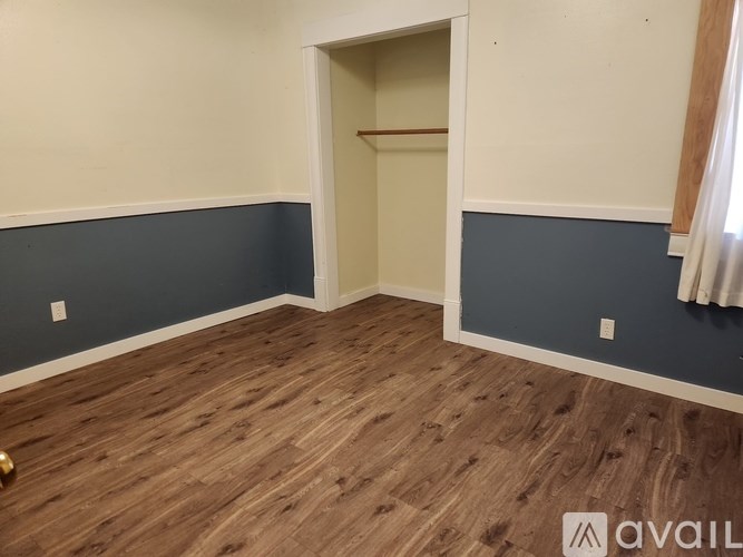 A room with a wooden floor and a wall painted in blue.