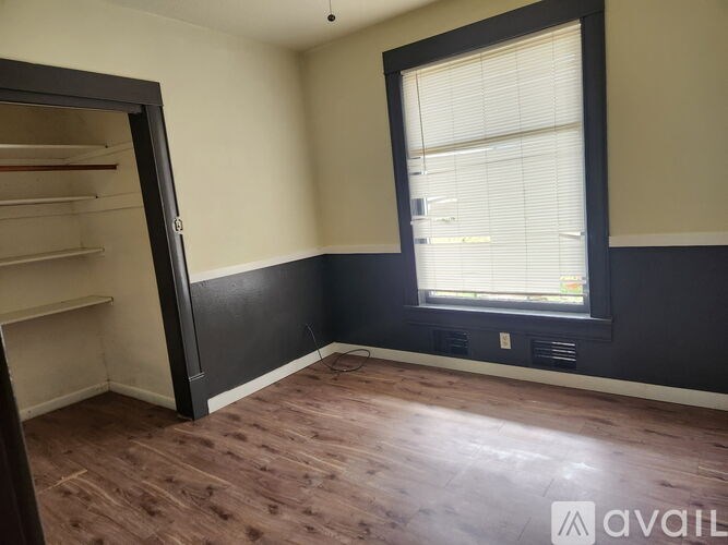 A room with a window and a door leading to another room.