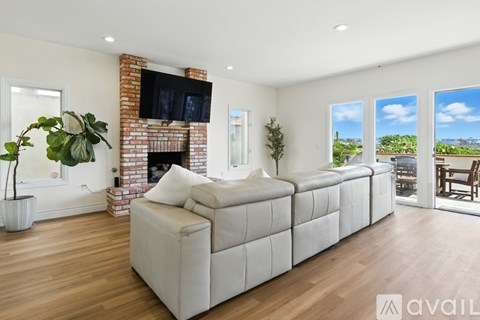 A living room with a white couch and a brick fireplace.