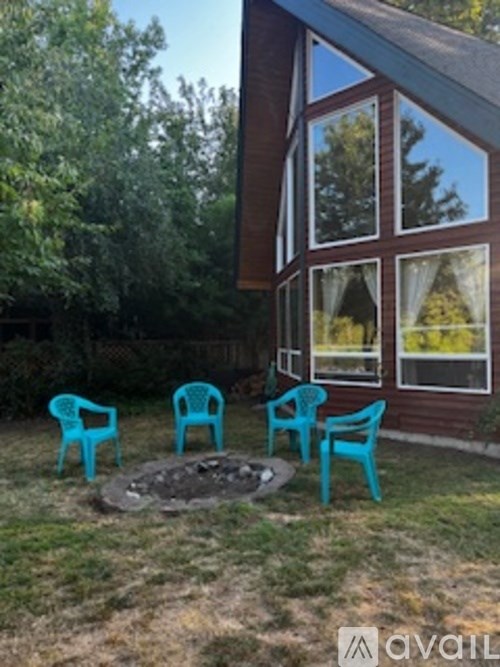 A backyard with a fire pit and chairs.
