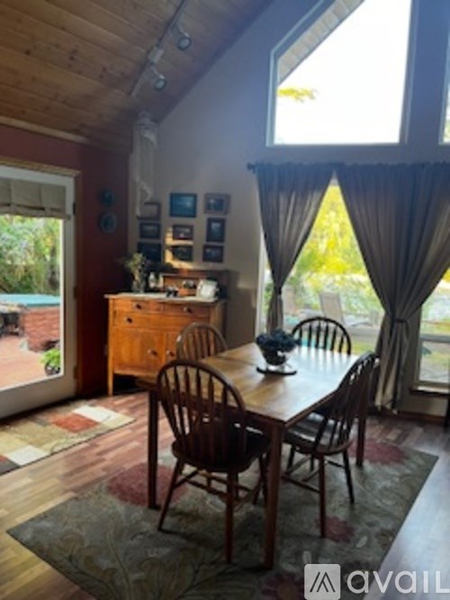A dining room with a wooden table and chairs.
