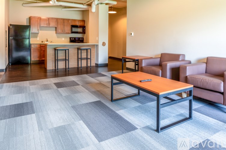 A modern kitchen with a black refrigerator and wooden cabinets.