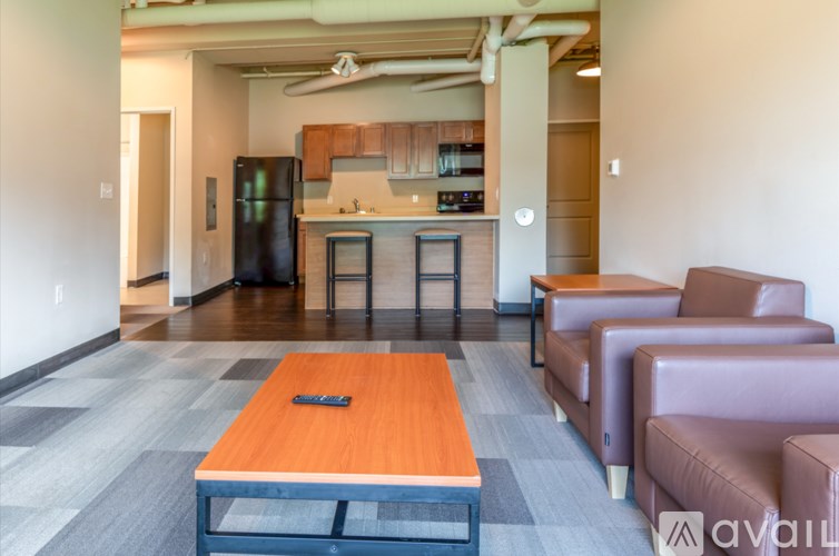 A modern living room with a kitchen in the background.