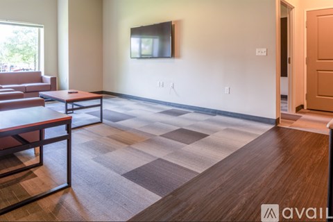 A living room with a brown couch and a wooden floor.