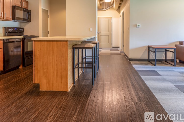 A kitchen with wooden floors and a bar area.