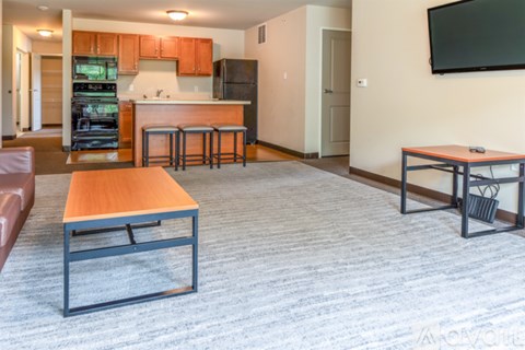 A modern kitchen with a dining table and a living room area.