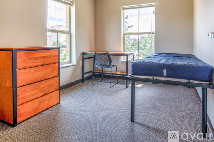 A bedroom with a bed, desk, and chair.