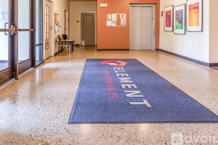 A hallway with a blue carpet that says "Element" on it.