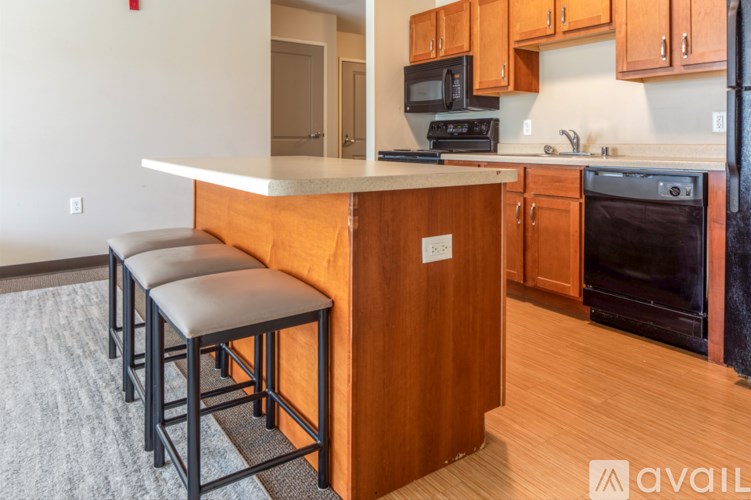 A kitchen with a counter and stools.