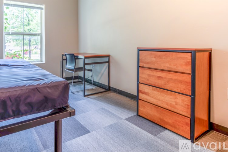 A bedroom with a bed, desk, and chair.