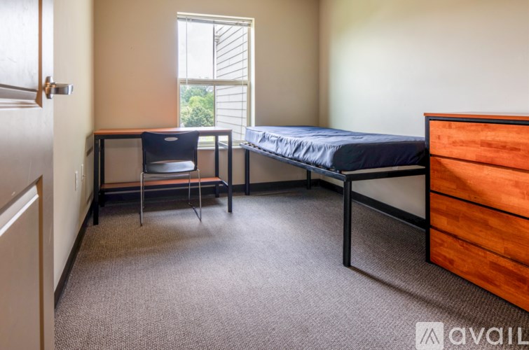 A bedroom with a bed, desk, and chair.