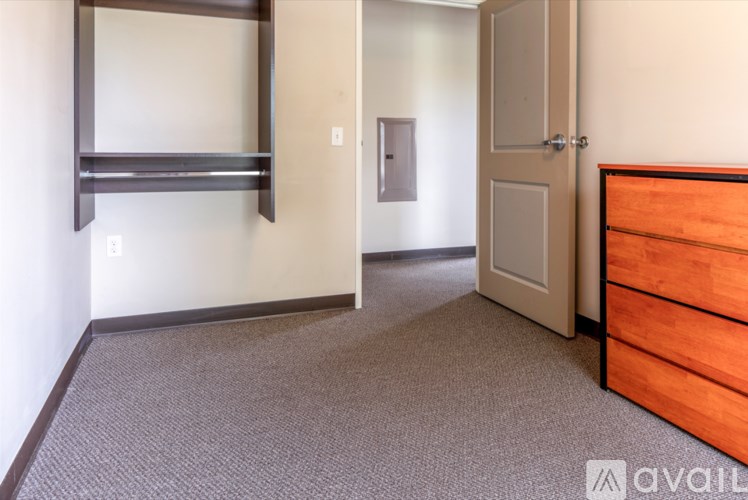 A room with a bed and a shelf on the wall.