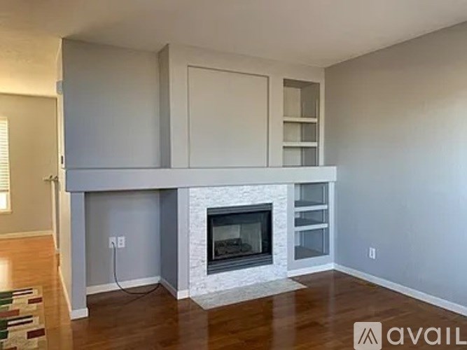 A living room with a fireplace and built-in shelves.