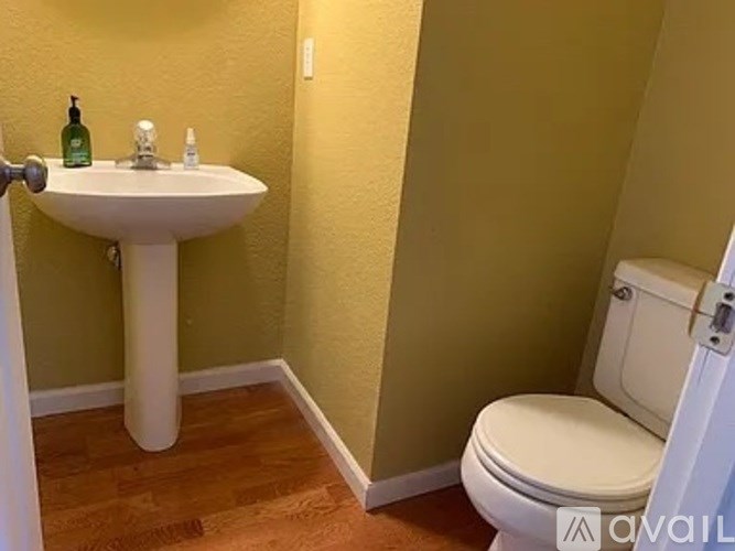 A bathroom with a sink, toilet and a door.