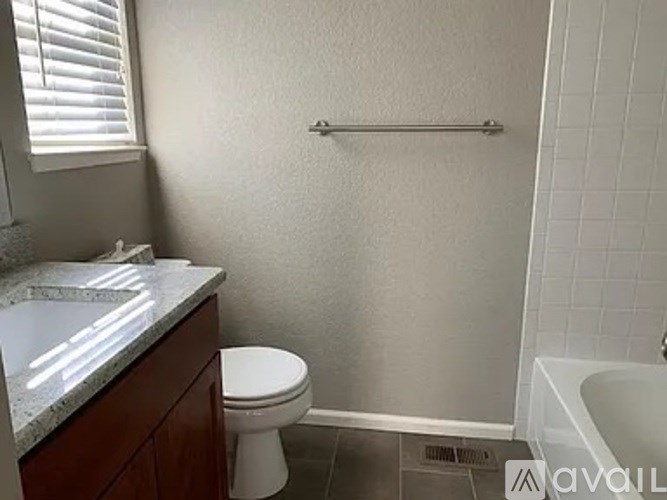 A bathroom with a toilet, sink, and bathtub.