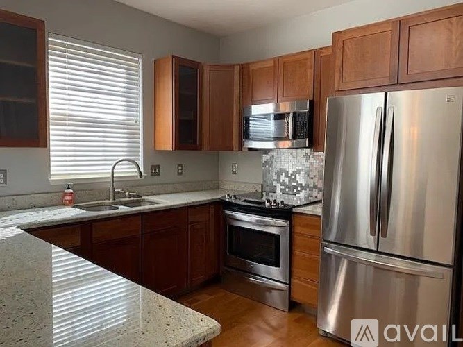 A kitchen with a granite countertop and stainless steel appliances.