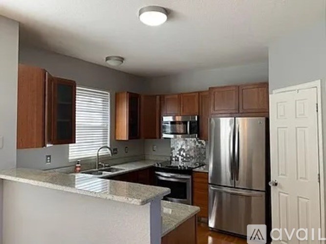 A kitchen with a refrigerator, sink, and cabinets.