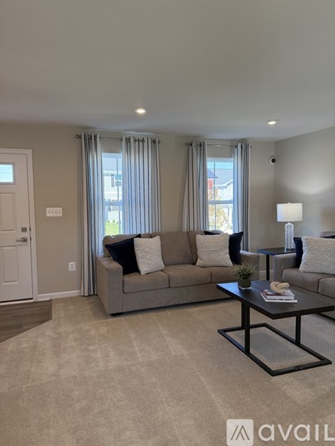 A living room with a grey couch, a coffee table, and a lamp.