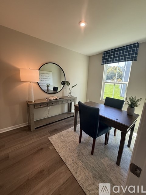 A room with a desk and a mirror on the wall.