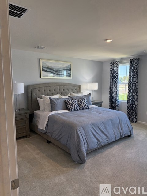 A bedroom with a large bed and a painting on the wall.