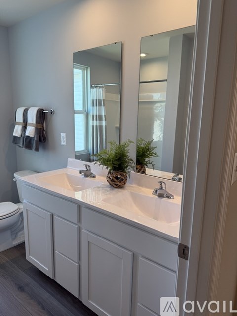 A bathroom with a white vanity and a mirror above it.