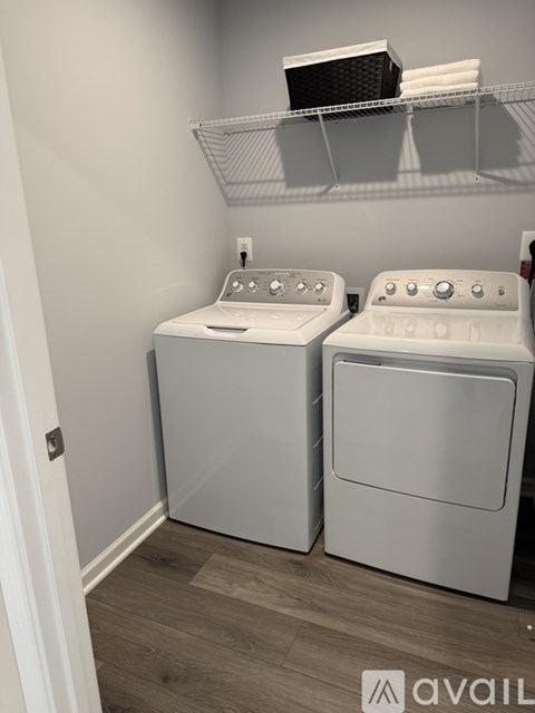 Two white front loading washing machines in a laundry room.
