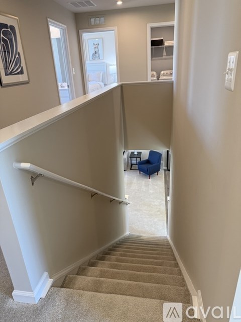 A staircase with a beige carpet and white walls.