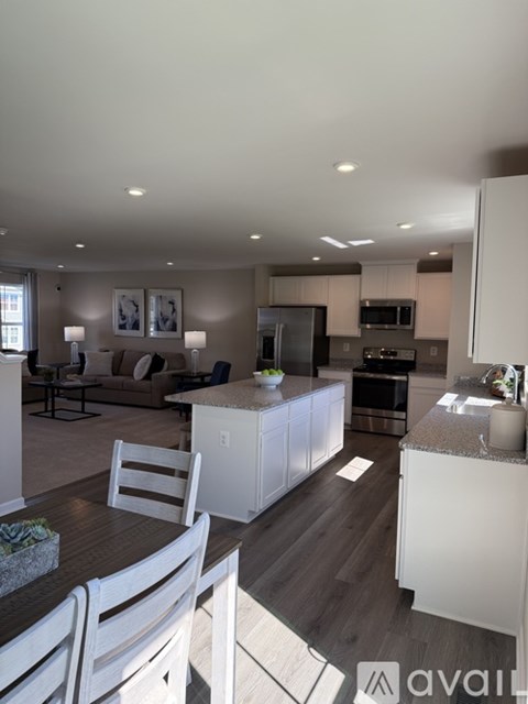 A modern kitchen with white cabinets and a dining table with chairs.
