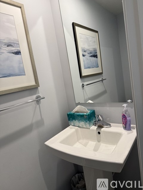 A bathroom with a white sink and a picture on the wall.