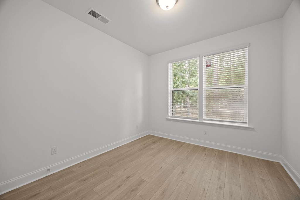 A room with a window and wooden flooring.