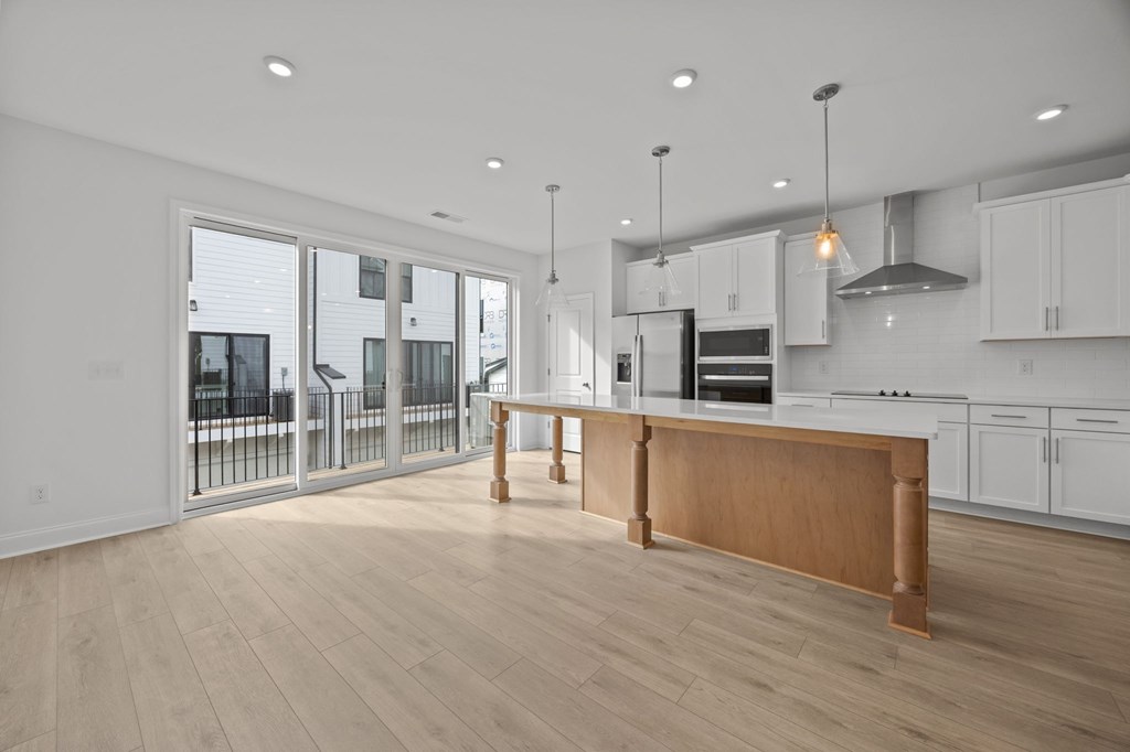 A modern kitchen with a wooden island and white cabinets.
