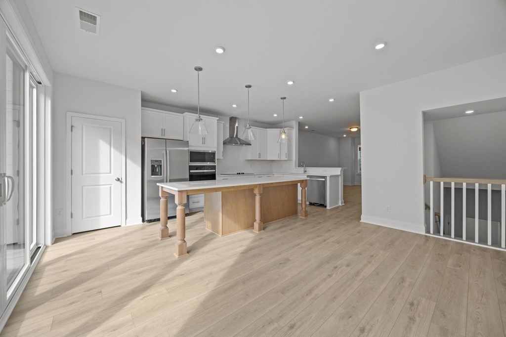 A modern kitchen with wooden floors and white walls.
