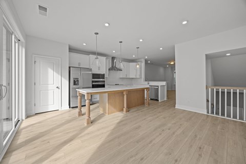 A modern kitchen with wooden floors and white walls.