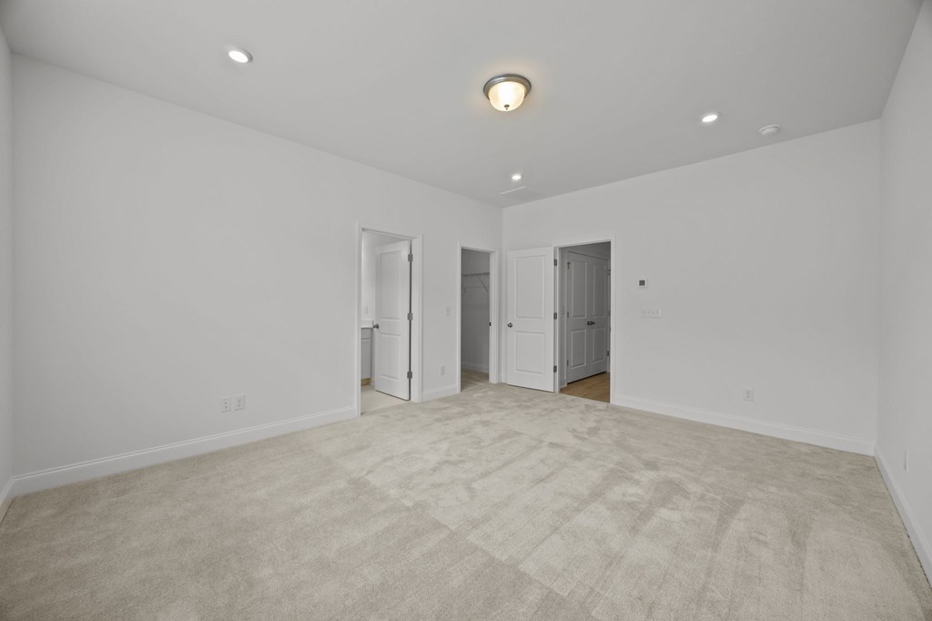 A large, empty room with a carpeted floor and white walls.