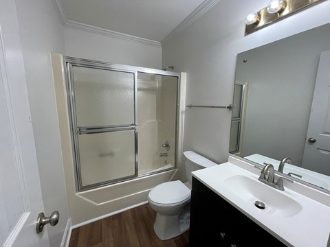 A white toilet sits in a bathroom next to a sink.