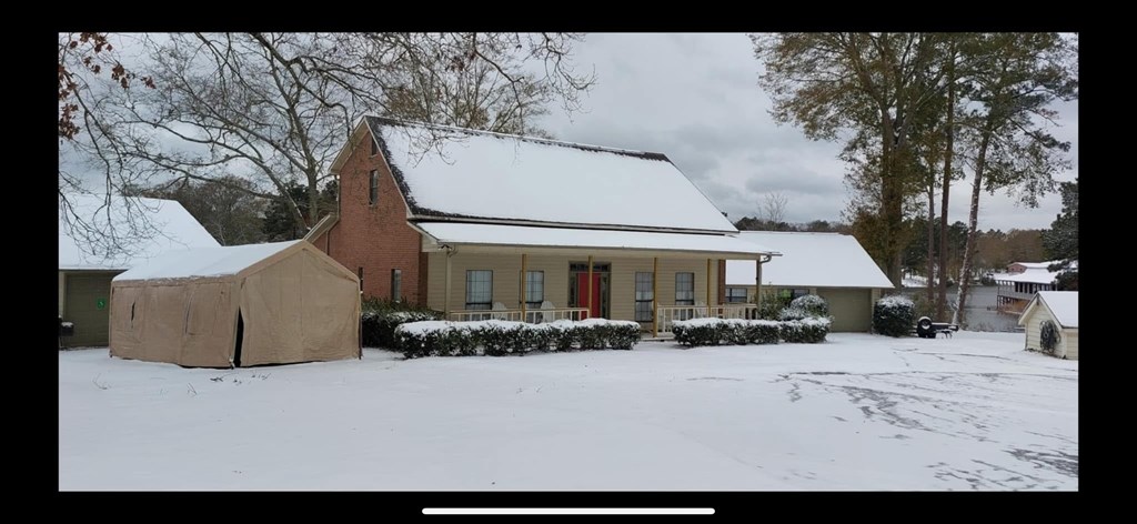 A house with a red door is surrounded by snow.