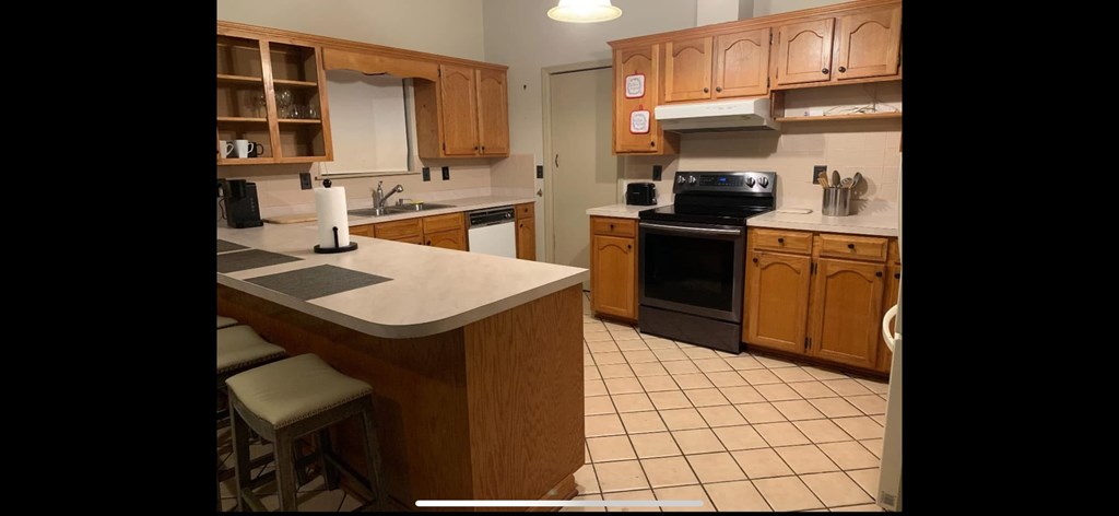 A kitchen with wooden cabinets and a black oven.