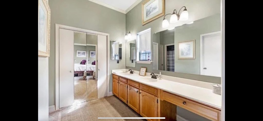 A bathroom with a vanity and a large mirror.