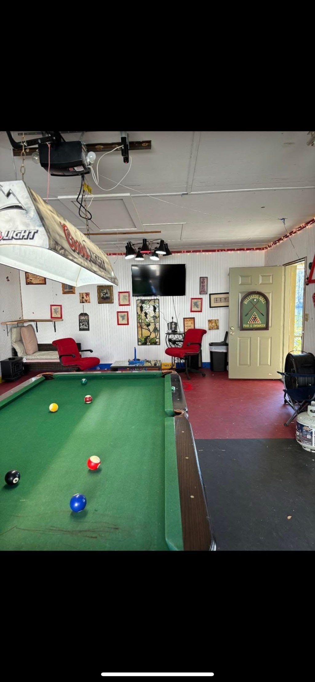 A pool table with a green felt cloth and several balls scattered across it.