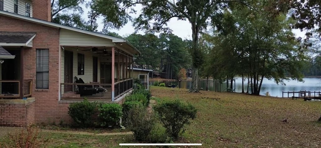 A house with a porch and a view of a lake.