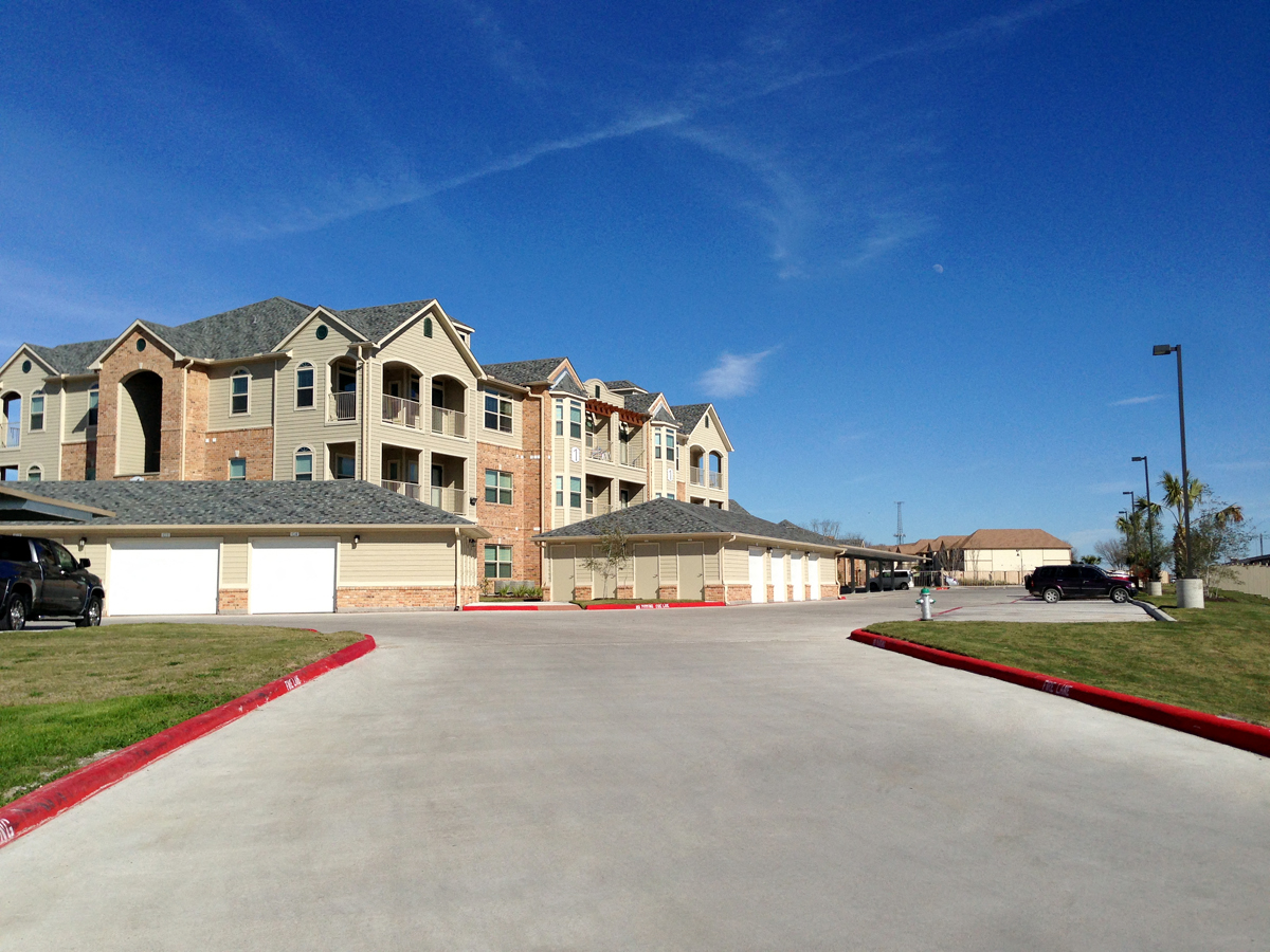 an empty parking lot in front of an apartment building