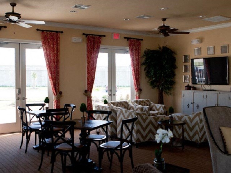 A living room with a couch, chairs, and a ceiling fan.