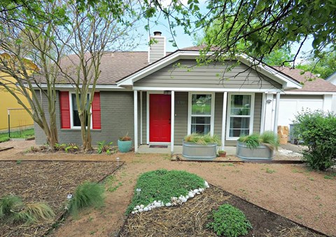 A house with a red door and a grey roof.