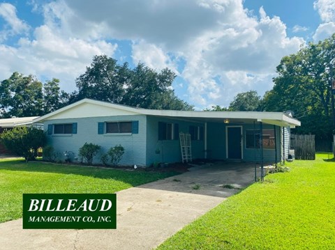 A house with a green lawn and a sign that says "Billeaud Management Co., Inc."