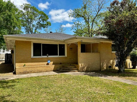 A small house with a blue sign on the front door.
